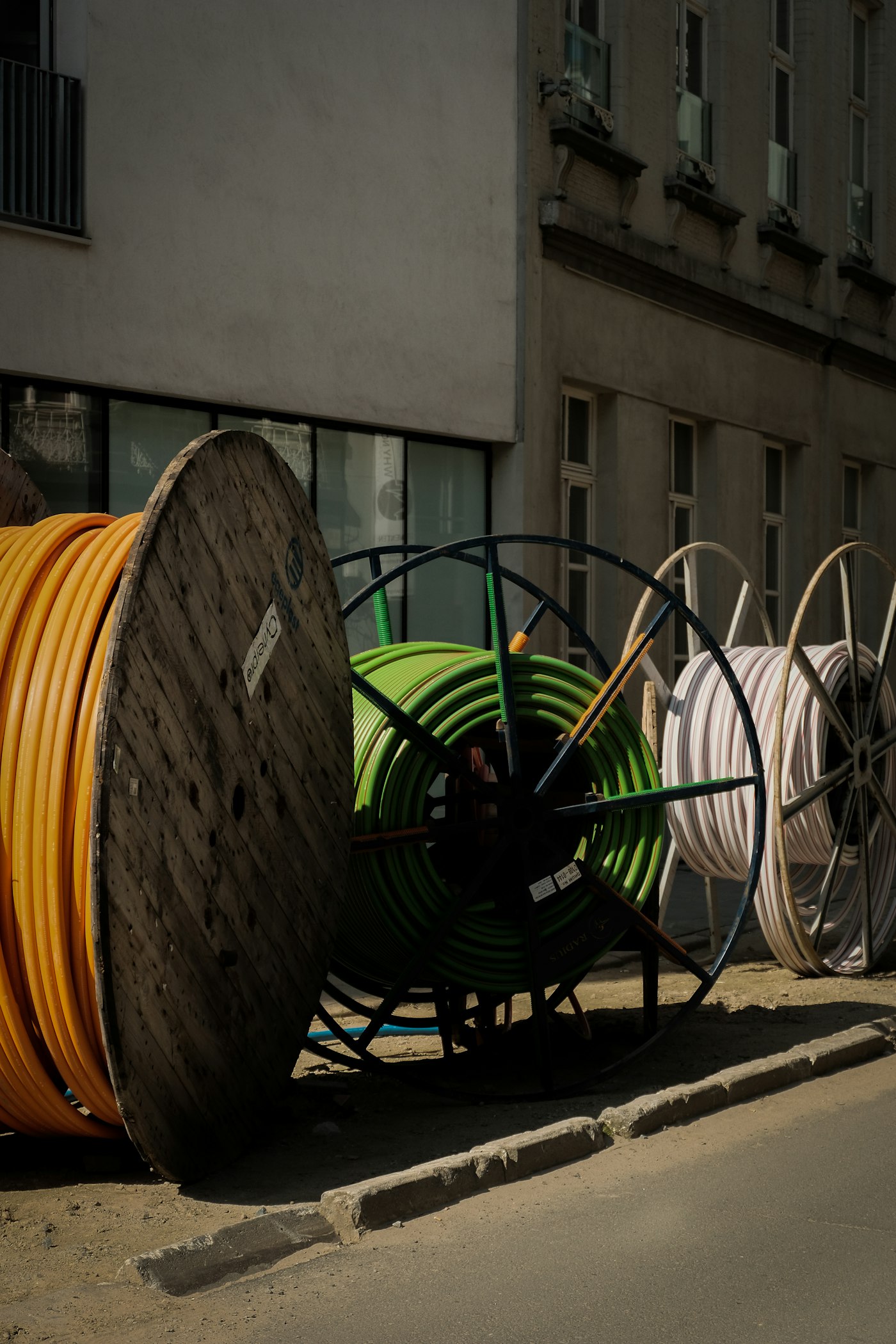 Kabeltrommeln mit Speedpipes am Straßenrand vor einem Wohnhaus